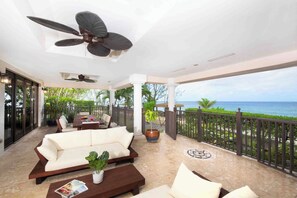 Oceanfront veranda furnished with an alfresco dining table and comfy lounge furniture. 