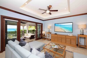 Welcome to Casa Luna #5. The villa's living area includes modern furnishings, an HD SmartTV, plus walkout access to the ocean veranda. 