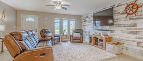 - Beautifully designed living room, perfect for relaxing & unwinding
- Reclining leather seating, a large TV & rustic coastal decor create a charming retreat
- Ideal space for movie nights, family gatherings, or simply kicking back in comfort