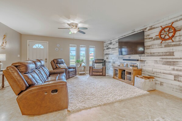 - Beautifully designed living room, perfect for relaxing & unwinding
- Reclining leather seating, a large TV & rustic coastal decor create a charming retreat
- Ideal space for movie nights, family gatherings, or simply kicking back in comfort