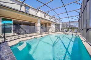 Relax by the sparkling screened-in private pool and spa, complete with sun loungers and a shaded patio area. Perfect for unwinding after a day at Disney, this outdoor oasis combines comfort & safety with a child-friendly pool fence and modern design.