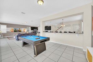 Challenge your friends and family to a game of pool in this inviting entertainment space. The sleek billiards table is perfectly positioned, with an open layout that connects seamlessly to the living area and patio for a lively vacation atmosphere.