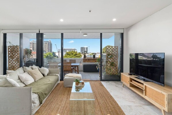 Relax on the plush sofa with direct access to the private balcony, where sweeping city views create the perfect backdrop for unwinding or catching up on your favourite shows.