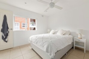 Sink into the queen-size bed, dressed in fresh linen, for a restful night. A ceiling fan ensures comfort year-round, while a built-in wardrobe provides ample storage space.