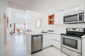Whip up your favorite dishes in this sleek, fully equipped kitchen with style to spare - Enjoy the seamless flow from cooking to lounging, ideal for shared moments - Bright, welcoming, and thoughtfully designed to make your stay unforgettable