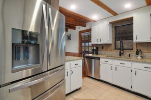 A modern kitchen with stainless steel appliances and white cabinets.