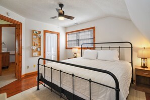 A bright bedroom with a black metal bed frame.