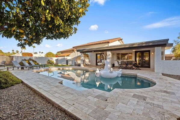Sparkling heated optional pool, putting green, fire pit, lounge areas, dining table, BBQ grill, sun loungers, swing chairs, and bocce ball.