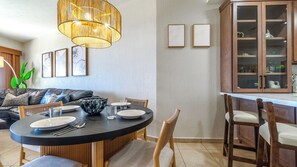 The dining table is set next to additional seating at the kitchen counter.
