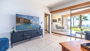 Large screen TV by sliding glass doors that access the patio.