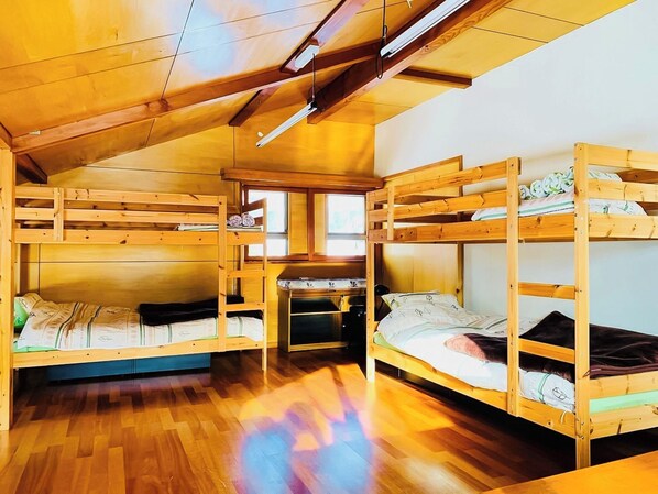 ・[Bedroom] This guest room is furnished with two bunk beds and has a warm, woody feel.