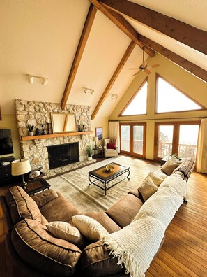 Spacious living room with vaulted ceilings and comfortable seating, ideal for relaxing or entertaining large groups.