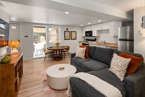 Your open-concept living/dining/kitchen area with Smart TV, full-sized fold out couch, and wood-burning fireplace.