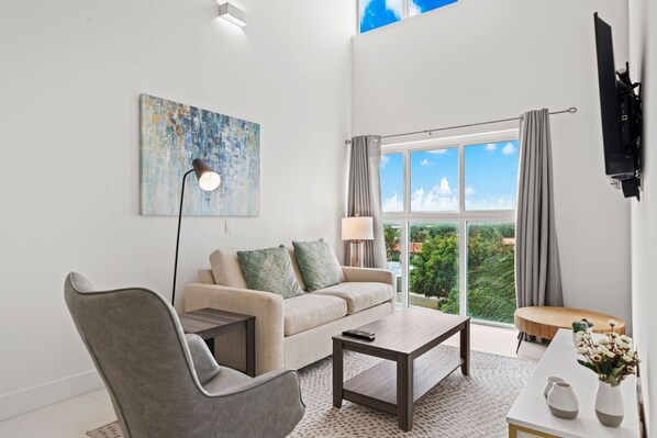 Soak up the natural light in this vibrant, open-concept living and dining area - Gather around the sleek dining table or kick back in the cozy lounge with loved ones - Welcoming space to laugh, connect, and make unforgettable memories together