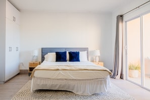 Bedroom features a king size bed, sliding doors to the private patio