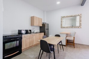 Kitchen with full size fridge and oven and a dining table for two