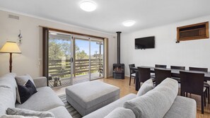 Open plan living/dining area with cosy fireplace and air conditioner