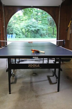 Ping pong table in the garage that opens on to the patio