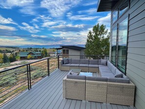 Plenty of outdoor furniture on the deck that overlooks the lake