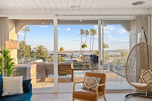 Bright and airy living room with a modern aesthetic, opening up to a stunning balcony view.