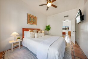 Bedroom 2 with cozy queen bed, stylish decor, smart TV, and closet