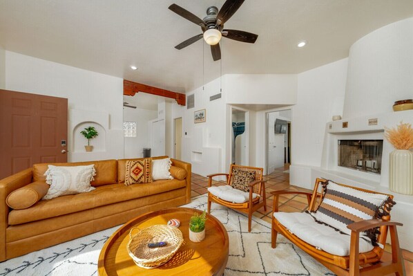 Bright, stylish living room with queen-size sofa bed, seating, and beehive fireplace (nonfunctional)