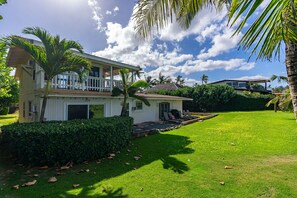 Spacious yard surrounded by tropical plants and ocean views.