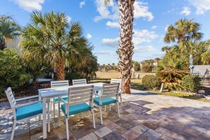 Patio with dining table and seating, steps to a nearby pool