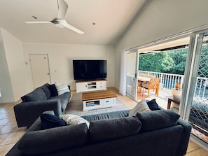Large Lounge with 85 inch smart TV exiting onto balcony