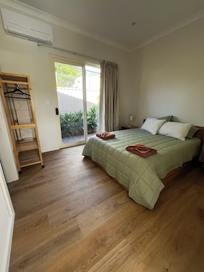 Generous and comfortable queen bedroom, leading to the outside courtyard space.
