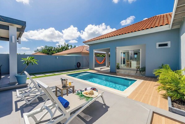 Relax and unwind in this serene pool area, complete with comfy lounge chairs and a cozy hammock for the ultimate escape.