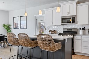 Fully stocked kitchen with stainless steel appliances and island seating