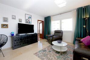 Spacious and bright lounge area with comfortable seating and Flat-Screen TV