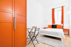 Sink into comfort in this modern bedroom with vibrant orange decor. Perfect for a peaceful night's rest. Book today and wake up refreshed!