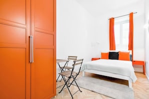 Sink into comfort in this modern bedroom with vibrant orange decor. Perfect for a peaceful night's rest. Book today and wake up refreshed!