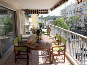 Balcon équipé d'une table avec vue sur l a mer.