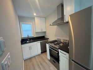 The kitchen is small but mighty, with gas stove, dishwasher, disposal, fridge.