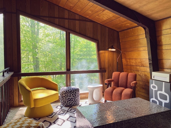 Loft lounge overlooking the trees and the living room below.
