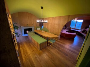Dining Room with fireplace and built in table and rock formation seating.