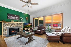 Stunning living room with stone fireplace, and mountain views.