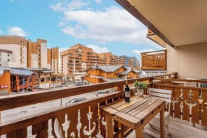 Balcon exposé plein sud avec vue sur la vallée et la station. Espace repas pour prendre le petit déjeuner, le déjeuner ou l'apéritif en profitant du soleil.