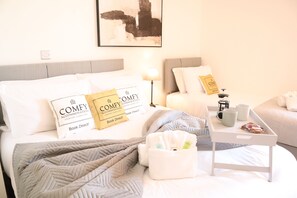 Bright and inviting bedroom featuring a comfortable double bed and single bed with plush linens, ideal for a restful and relaxing stay