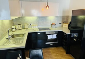 Fully equipped modern kitchen featuring essential appliances, ample counter space, and stylish finishes, perfect for preparing meals during your stay