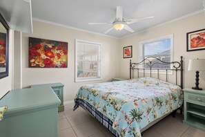 King sized bed, with nightstands, fan, and closet.
