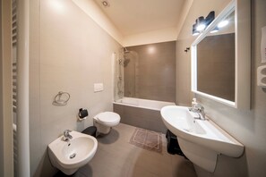 Private bathroom with bathtub, shower, toilet and bidet. 