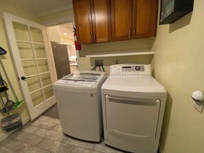 Laundry room with LG washer and dryer, cleaning supplies, and first aid kit