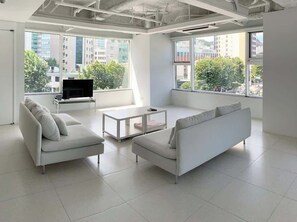 Spacious living room with a large sofa and smart TV with a great urban view.  This living room is large. Great for small gatherings and receiving guests.