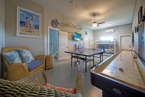 Game room with ping pong, a shuffle board, and a twin-over-twin bunk bed.