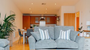The living room connects to the modern kitchen with full range of appliances