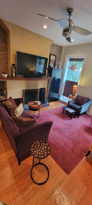 velvet sofas & chairs and 70" smart tv in the living room.